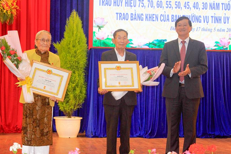 Đồng chí Trần Đức Quận - Ủy viên Ban Chấp hành Trung ương Đảng, Bí thư Tỉnh ủy trao huy hiệu 75 năm tuổi đảng cho 2 đảng viên Nguyễn Tấn Y, Đoàn Thị Hòe
