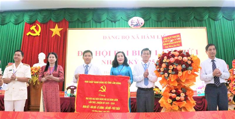 Đồng chí Võ Thanh Bình, Ủy viên Ban Thường vụ Tỉnh ủy, Trưởng Ban Tuyên giáo và Dân vận Tỉnh ủy trao tặng bức trướng của Ban Chấp hành Đảng bộ tỉnh Lâm Đồng và hoa chúc mừng Đại hội
