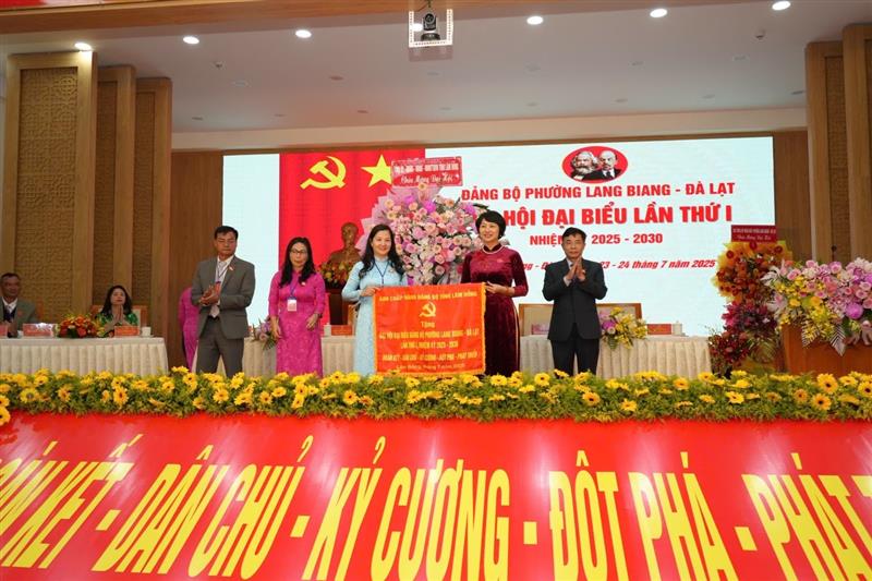 Đồng chí Phạm Thị Phúc, Phó Bí thư Tỉnh ủy, Chủ tịch Uỷ ban MTTQ Việt Nam tỉnh Lâm Đồng trao bức trướng của Ban Chấp hành Đảng bộ tỉnh cho Đại hội với dòng chữ Đoàn kết - Dân chủ - Kỷ cương - Đột phá - Phát triển