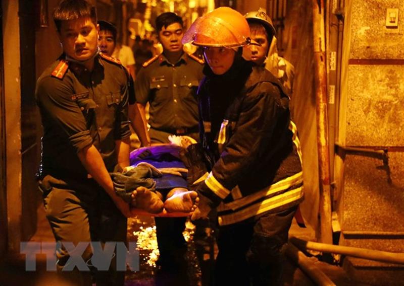 Lực lượng chức năng đưa nạn nhân ra khỏi hiện trường. (Ảnh: TTXVN)