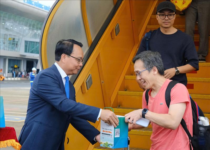 Phó Bí thư Thường trực Tỉnh ủy Đặng Hồng Sỹ tặng quà cho hành khách khi hạ cánh xuống Sân bay Liên Khương