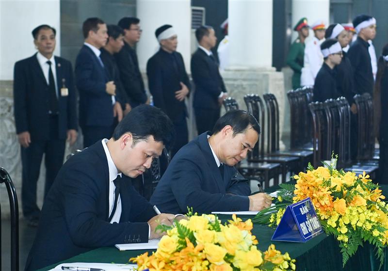 Đồng chí Nguyễn Thái Học - Quyền Bí thư Tỉnh ủy Lâm Đồng (bên phải) viết sổ tang viếng Tổng Bí thư Nguyễn Phú Trọng.